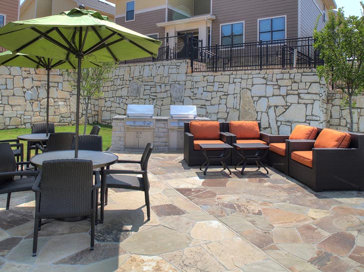 Sun Deck area at Villas on Sycamore including covered seating and outdoor lounge chairs. Located Near Sam Houston State