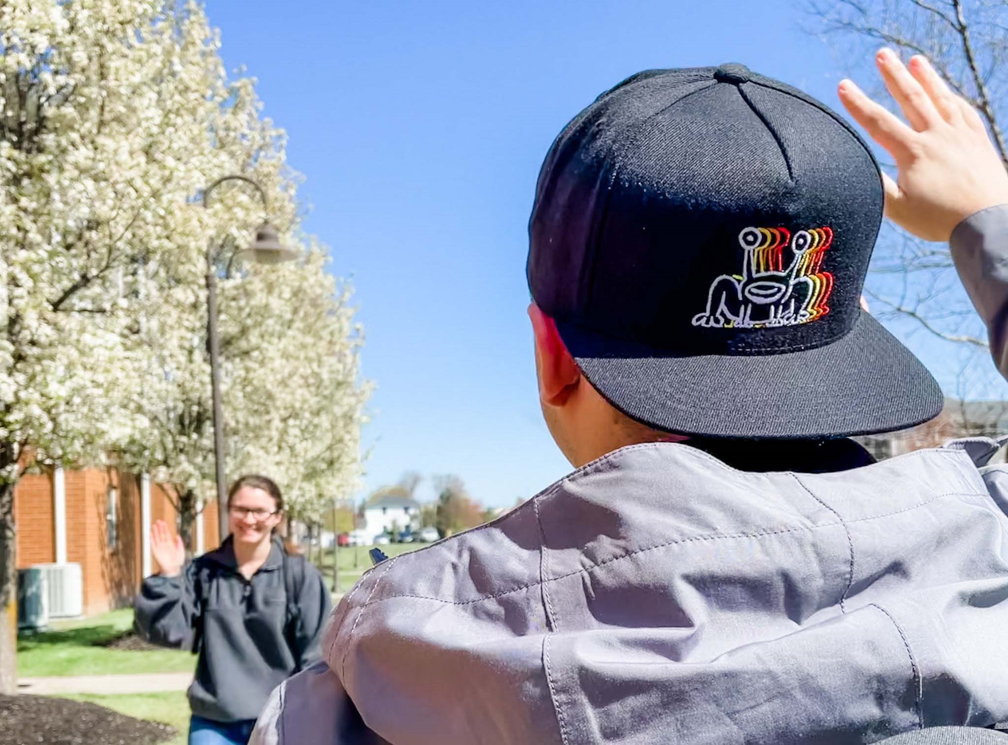 Students waving at eachother on campus